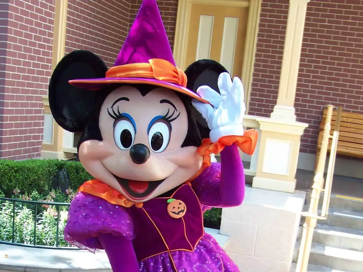 Minnie dressed in a purple and orange witch costume. minnie's holiday dine