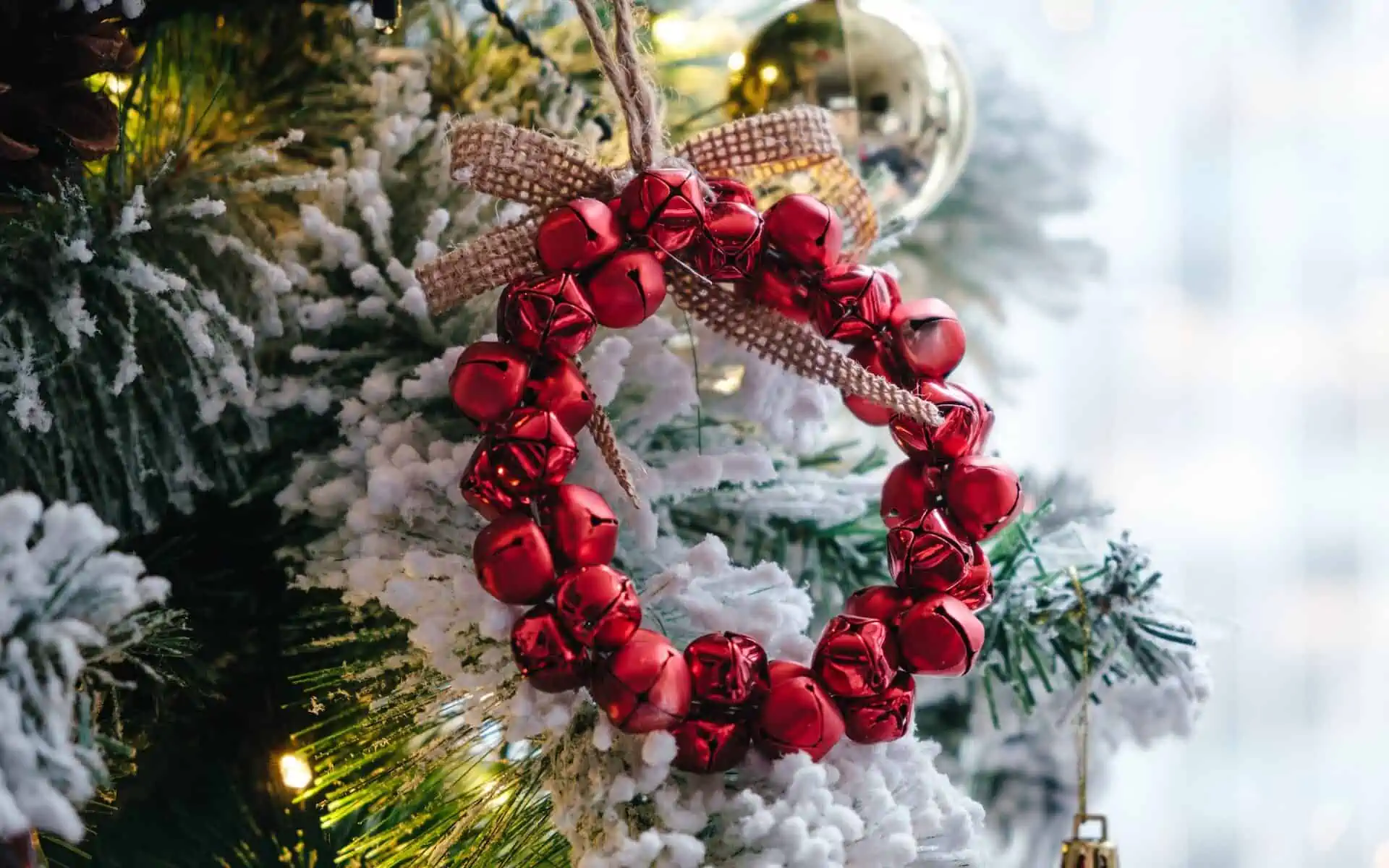 Jingle bell wreath hangin on tree.